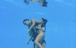 L'entraîneure de l'équipe américaine de nage artistique et synchronisée Andrea Fuentes (d) vient sauver sa nageuse Anita Alvarez qui a perdu connaissance lors des Mondiaux de natation, à Budapest, le 22 juin 2022