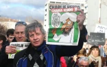 Des manifestants lors de la marche républicaine du 11 janvier 2015 à Paris brandissent des exemplaires du dernier Charlie Hebdo