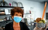 Maddalena sert une glace Ă un client chez Brivido dans le quartier de Testaccio Ă Rome alors que le pays a assoupli son confinement contre le coronavirus, le 26 mai 2020