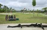 Des visiteurs sont assis, le 1er août 2025, sur un banc du parc urbain d'Akouédo, à Abidjan, construit sur le site d'une ancienne décharge