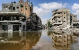 Des eaux usées provenant de canalisations souterraines effondrées couvrent un secteur de Khan Younès où des bâtiments ont été détruits, dans le sud de la bande de Gaza, le 8 juillet 2024