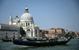 Des gondoliers naviguent sur le Grand Canal dans la lagune de Venise le 25 juin 2025, où le mariage de Jeff Bezos et de Lauren Sanchez irritent certains habitants