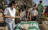 Des habitants du kibboutz de Kfar Aza dans le sud d'Israël, se recueillent devant une tombe lors d'une cérémonie en hommage aux personnes tuées lors de l'attaque du Hamas le 7 octobre 2023, le 16 octobre 2025