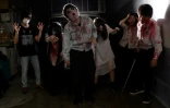 Des acteurs grimés en zombie lors d'un spectacle de maison hantée en version drive-in, le 15 juin 2020 à Tokyo, au Japon