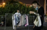Un vendeur de rue propose des vêtements aux clients, le long d'une rue de Pékin, le 10 juin 2020