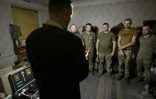 Un aumônier prie avec des militaires ukrainiens de la 59e brigade lors de sa visite à leur position pour célébrer la Pâque orthodoxe, le 5 mai 2024 dans la région de Donetsk