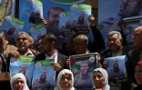 Des gens tiennent des portraits de Khader Adnan, un militant du Jihad islamique palestinien qui menait une grève de la faim en prison depuis près de trois mois, lors d'un rassemblement après l'annonce de sa mort, le 2 mai 2023, dans la ville de Gaza 