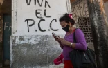 Une Cubaine passe devant un graffiti disant "Vive le PCC", le Parti communiste cubain, Ă La Havane le 6 avril 2021