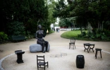 "Salon", la sculpture créée par l'artiste américaine Alison Saar pour les Jeux de Paris le 21 juin 2024. L'oeuvre est composée d'une femme noire tenant un rameau d'olivier et une flamme dorée et de six sièges symbolisant tous les continents