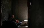 Antonio Lemos, un aide-cuisinier à la retraite, se repose sur un matelas posé au sol dans une maison abandonnée où il vit, dans le quartier de Belem à Lisbonne, le 17 avril 2025 au Portugal