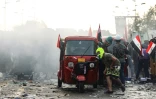 Des manifestants irakiens se réfugient derrière un tuk-tuk lors de heurts avec les forces de sécurité, le 29 octobre 2019 à Bagdad