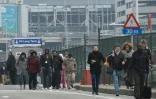 Des passagers quittent l'aéroport de Bruxelles à Zaventem évacué après deux explosions le 22 mars 2016