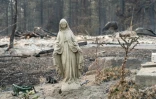 Une statue de la Vierge Marie près des ruines d'une maison détruite par le feu à Spokane (Etats-Unis) le 2 août 2026