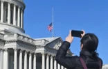Une femme prend une photo du drapeau américain en berne au Capitole en l'honneur de l'ancien président américain Jimmy Carter, à Washington, aux Etats-Unis, le 30 décembre 2024