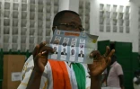 Un membre de la Commission électorale ivoirienne montre un bulletin de vote pendant le comptage des voix, le 31 octobre 2020 à Abidjan