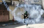 Un manifestant palestinien renvoie une cartouche de gaz lacrymogène sur des soldats israéliens le 31 mars 2018 à Hébron, en Cisjordanie