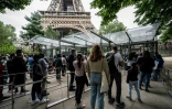 Des visiteurs font la queue devant la Tour Eiffel le jour de sa réouverture,le 16 juillet 2021 à Paris