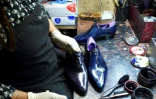 Une employée apporte la touche finale à une paire de chaussures dans l'atelier Berluti à Paris, le 3 mai 2016