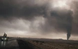 Un véhicule militaire irakien sur une route près de Qayyarah (sud de Mossoul), le 4 novembre  2016, sous un ciel noir envahi par la fumée des incendies de puits pétroliers