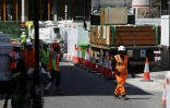 Des ouvriers du bâtiment se regroupent à l'ombre sur un chantier du centre de Londres, le 24 juin 2026