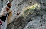 Un mineur inspecte à la lampe un pan de roche dans un gisement de néphrite dans la montagne de Goshta, dans l'est de l'Afghanistan, le 18 janvier 2025 