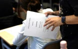 Un professeur tient en mains les sujets de l'épreuve de philosophie du bac, le 15 juin 2022 au lycée Arago à Paris