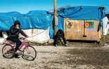 Un jeune migrant fait du vélo dans le camp de la "Jungle" à Calais, le 4 mars 2016