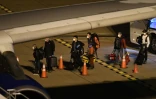 Des passagers évacués du paquebot australien Greg Mortimer attendent pour monter dans un avion à destination de Melbourne, le 11 avril 2020 à l'aéroport de Ciudad de la Costa, près de Montevideo, en Uruguay