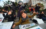 Des manifestants portent des masques à l'effigie de la présidente sud-coréenne Park Geun-Hye et de sa confidente Choi Soon-Sil à Séoul, le 29 octobre 2016 pour dénoncer un scandale de corruption impliquant les deux femmes