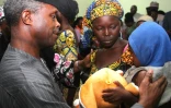 Une des 21 lycéennes de Chibok libérée pleure en tenant son bébé sous le regard du vice-président nigérian Yemi Osinbajo à Abuja le 13 octobre 2016