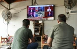 Des hommes regardent l'annonce de la dissolution du PKK sur un écran de TV à Diyarbakir, en Turquie, le 12 mai 2025