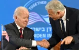 Le président américain Joe Biden (G) et le Premier ministre israélien Yaïr Lapid se serrent la main avant une conférence de presse conjointe à Jérusalem, le 14 juillet 2022