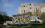 Un graffitt peint sur un mur indiquant l'emplacement d'un trafic de drogue (Here Coffee Bernex) dans le quartier de La Castellane, à Marseille, le 20 mars 2024