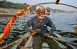 Le batelier Chhote Lal Nishad à bord de sa barque traditionnelle sur la rivière Yamuna, à Prayagraj, le 31 janvier 2025 en Inde