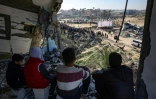 Des jeunes palestiniens se préparent à assister à la libération des trois otages israéliens par le Hamas, le 15 février 2025 à Khan Younes, dans la bande de Gaza
