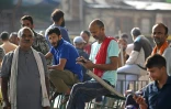 Des ouvriers migrants indiens attendant des clients à la recherche de main-d’œuvre journalière sur un marché de Srinagar, le 24 août 2026