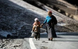 Une femme et ses enfants marchent le long d'une route à Dawu dans la préfecture autonome tibétaine de la province du Sichuan en Chine, le 8 décembre 2015