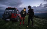 Le chef des secours en montagne des Maramures, Dan Benga (g), reçoit un appel d’urgence, sur un plateau proche de la frontière roumano-ukrainienne, le 15 mai 2024