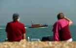 Un couple observe un bateau du secours en mer britannique sur la plage de Dungeness, le 7 septembre 2021, dans le sud-est de l'Angleterre