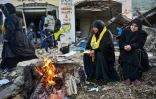 Des habitants d'Aitaroun, dans le sud du Liban, attendent près d'un feu alors que les soldats libanais les empêchent d'entrer dans leur village où les forces israéliennes sont toujours présentes, le 27 janvier 2025