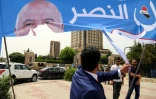 Un Kurde irakien déchire une banderole de campagne du Premier ministre Haider al-Abadi, à l'aube des élections parlementaires prévues le 12 mai