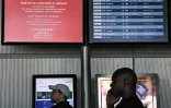 Des passagers consultent le tableau d'affichage des départs à l'aéroport Roissy Charles-de-Gaulle, près de Paris, pendant la grève des contrôleurs aériens français, le 3 juillet 2025