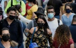 Des passants portent des masques faciaux dans la rue à Mexico le 2 août 2021, alors que la ville est passée en alerte orange en raison de l'augmentation des cas de COVID-19