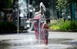 Un enfant se rafraîchit dans un parc à Bruxelles le 19 juin 2026