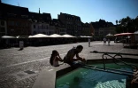 Des personnes se rafraîchissent à une fontaine publique dans une rue de Mulhouse, pendant un épisode de canicule, le 22 août 2023