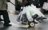 Un homme pousse un chariot de sacs en plastique, chargés de courses, à Manhattan le 28 février 2020, deux jours avant l'entrée en vigueur d'une interdiction de la plupart des sacs en plastique

