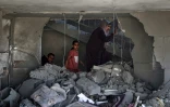 Une Palestinienne et des enfants dans les décombres d'une maison touchée par des bombardements israéliens nocturnes à Rafah, dans le sud de la bande de Gaza, le 20 avril 2024