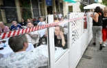 Des manifestants installent un ruban sur la terrasse d'un restaurant pour protester contre le surtourisme, le 6 juillet 2024 Ă Barcelone