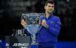 Novak Djokovic fier du trophée récompensant le N.1 mondial à l'issue de la saison, en marge de son match contre le Norvégien Casper Ruud à Turin, le 15 novembre 2021 