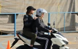 Mona apprend à conduire une moto avec Narghe comme passagère, lors d'une leçon dans un centre d'entraînement du nord de Téhéran, le 7 décembre 2025 en Iran